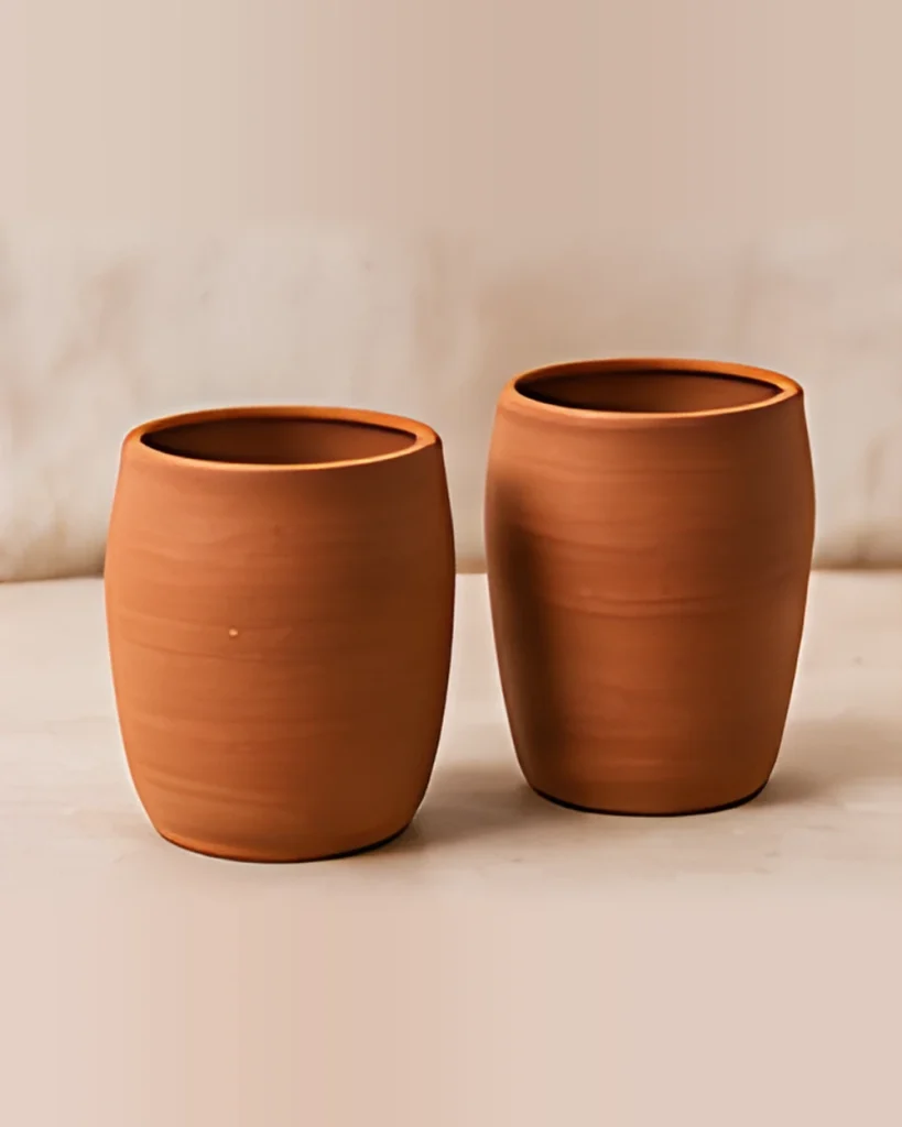 Two terracotta water tumblers side by side on a light surface