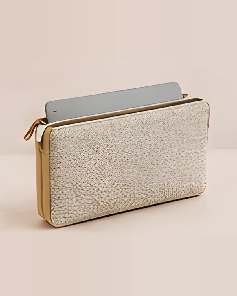 A slim woven fabric laptop sleeve with a tan trim, partly open with a laptop inside